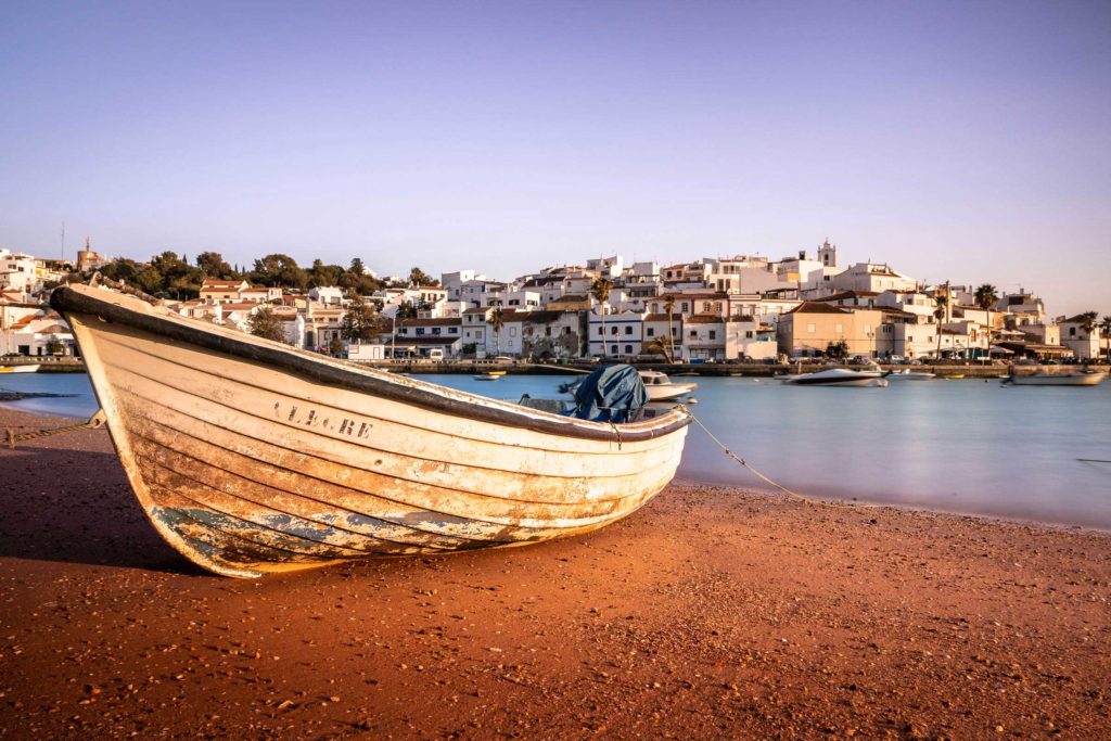 Altes Fischerboot am Strand eines Küstenorts an der Algarve in Portugal – stimmungsvolle Reisefotografie von Daniel Lampe