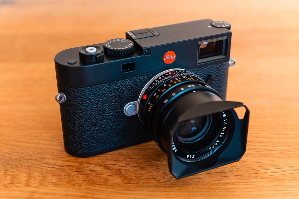 Leica M11 Digitalkamera mit 35mm Summilux Objektiv auf Holztisch – hochwertige Premium Kamera für Landschafts-, Reise- und Streetfotografie.