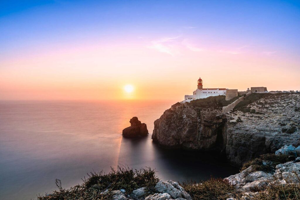 Leuchtturm am Cap São Vicente an der Algarve im warmen Licht des Sonnenuntergangs über dem Atlantik
