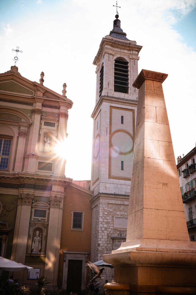 Sonnenlicht fällt am Sommerabend auf die Kathedrale Sainte-Réparate und den Obelisk-Brunnen in Nizza